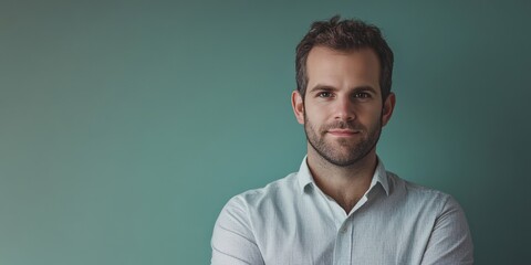 Obraz premium Confident Young Man Posing Against a Soft Green Background in a Casual Shirt