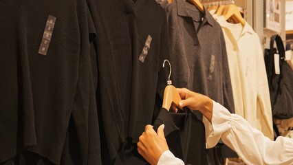 Conscious shopper explores eco-friendly sweater collection selecting sustainable fabric options Slow fashion mindset promotes responsible consumer behavior highlighting ethical fashion choices 