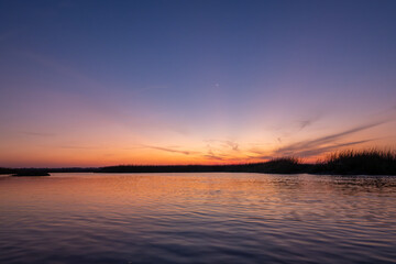 Sunset reflection on river with marsh