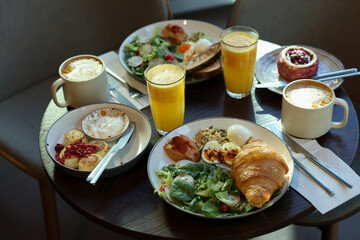 Tasty breakfast. Different meals and drinks served on wooden table in cafe