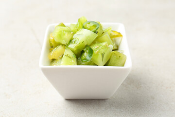 Delicious salsa (Pico de gallo) in bowl on light textured table, closeup