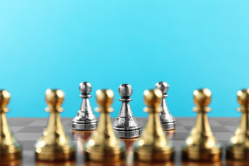 Silver pawns in front of other golden ones on chessboard. Competition concept