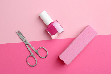 Pedicure procedure. Nail polish in bottle, buffer and scissors on pink background, flat lay