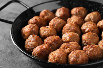 Tasty meatballs in baking dish on grey table, closeup