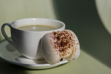Green latte matcha with white cacao macaron dessert on pastel background with creative deep shadows. Concept of holiday breakfast morning tea drink. Cozy minimalist superfood vibrant colors healthy