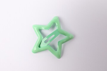One green star shaped hair clip on white background, top view