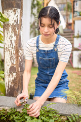 Woman pruning plants near a backyard pond
