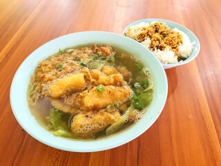 Asian fish soup. Close up view of tasty asian fried and sliced fish soup serve in a blue bowl. Asian food concept