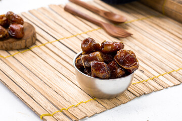 Delicious dried dates, popular fruit dates during the month of Ramadan on a bamboo mat