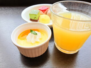 Tasty dessert after meal. Flat lay of tasty dessert consisting of mini cheese cake , Japanese mochi , mango pudding and orange juice after meal