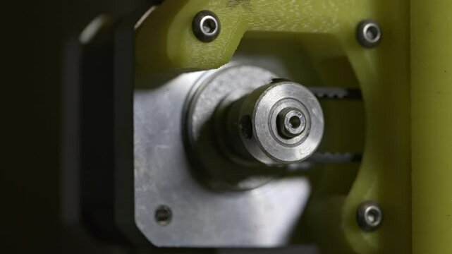 3d printer stepper motor pulley, close up view showing precision technology in use.  Rotating pulley turning x axis belt.