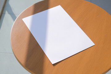 paper a4 mockup design. blank paper poster mockup on wooden coffee table , shadow overlay