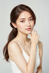 A woman with long hair and a white tank top is posing for a photo