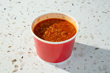 A view of a restaurant style cup of chili.