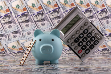 Blue piggy bank with a ladder against a background of 100 US dollar bills © Max Zolotukhin
