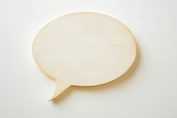 A wooden speech bubble placed on a bright white surface
