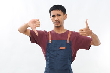 Fototapeta premium Young Asian young man showing thumbs up and thumbs down, difficult choose concept. Isolated on white background