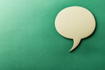 A singular paper speech bubble rests on a green background