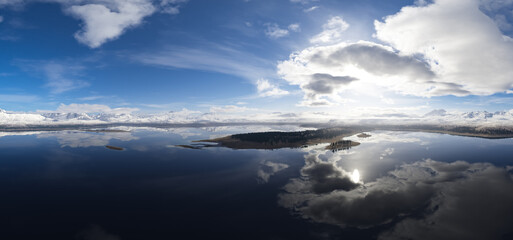 Obraz premium Majestic Snow-Capped Mountains Reflected on a Serene Lake Beneath a Vibrant Sky