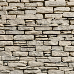 Photo texture of a wall made of stones hewn to look like brick.