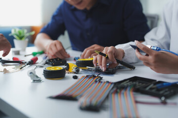Engineers designing and building electronic prototype in office