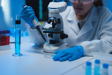 Scientist analyzing sample with micropipette in laboratory