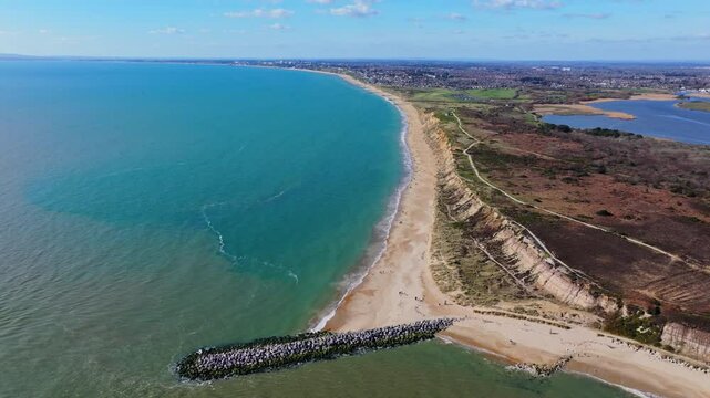 Aerial shot tracking along the Dorset coastline at Hengistbury Head, UK