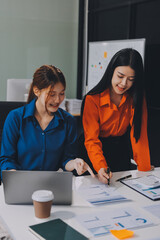 Entrepreneur Asian businessman and businesswoman discussing new business project in tablet in modern Meeting In Modern Office, Asian business casual concept.