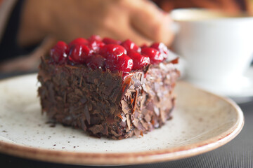 Delicious chocolate cake topped with cherries served at a cafe