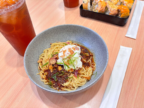 dinner with chili oil noodles, sushi variants, and fresh iced tea ready to enjoy
