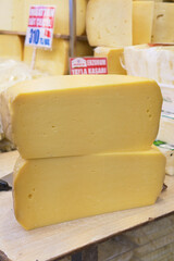 Yellow cheese block displayed in a market stall with signage