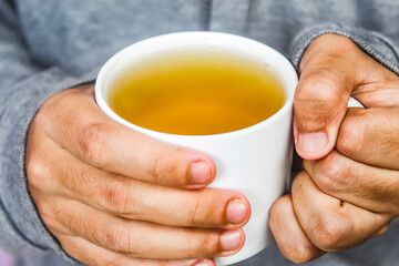 Hands holding cup of tea