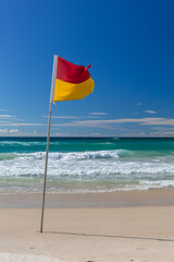 Australian surf lifesaving flag on a surf beach with surf in the background