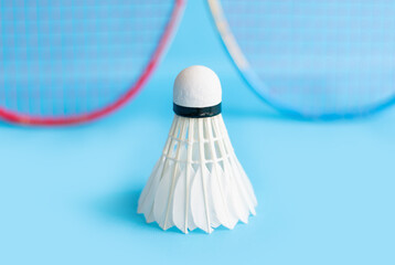 Badminton sport equipments, racket and white cream shuttlecock feather ball on blue floor, soft and...