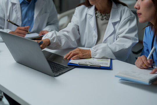 Medical team analyzing data on laptop during meeting