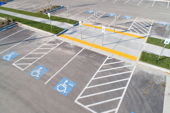Fototapeta A parking lot with handicap parking spaces and a crosswalk