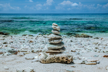 Small stones arranged in a pyramid shape on the beach