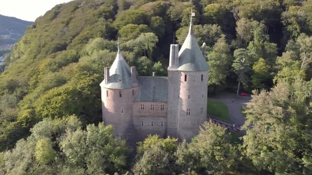 Drone view of Castell Coch, The Red Castle in Cardiff, Wales, UK, nestled within treetops hills
