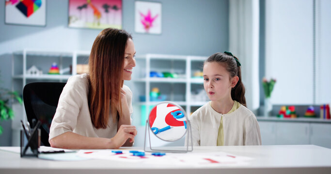 Young child learns to speak with speech therapist's assistance