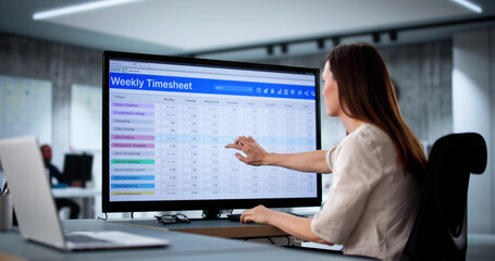 Woman in office signs weekly payroll time sheet for overtime