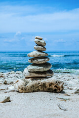 Small stones arranged in a pyramid shape on the beach