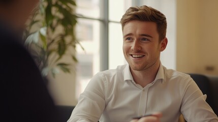 Naklejka premium Smiling businessman in a meeting, office setting, positive business communication