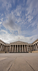 Fototapeta premium Neoclassical facade of the British Museum in London, with its symmetrical columns, emphasizes the museum historic legacy under an open sky.