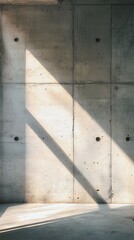 Modern interior showcasing light and shadows on concrete wall.