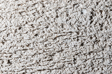 A wall with a rough texture and a few cracks