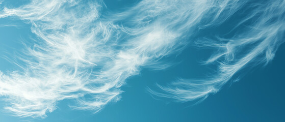 Wispy cirrus clouds float gracefully against deep blue sky, creating serene atmosphere