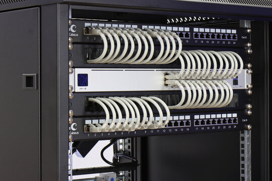 An Ethernet data switch connected to patch panels using patchcords. Installed in a telecommunications rack. 
