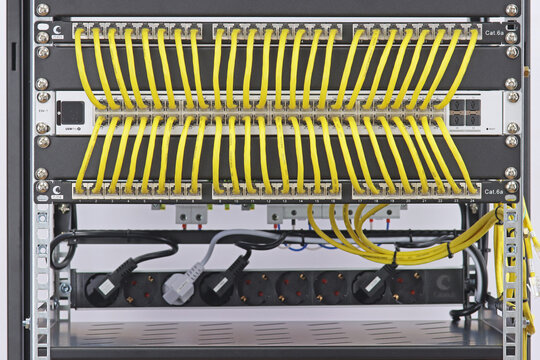 An Ethernet data switch connected to patch panels using patchcords. Installed in a telecommunications rack. 
