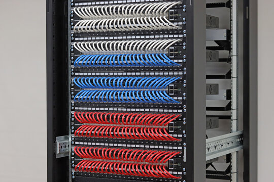 An Ethernet data switch connected to patch panels using patchcords. Installed in a telecommunications rack. 