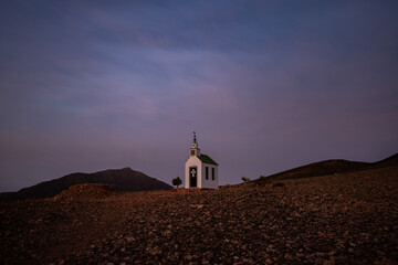 small cute white wooden chapel in a barren volcanic landscape. Sunrise, landscape shot of Ermita...